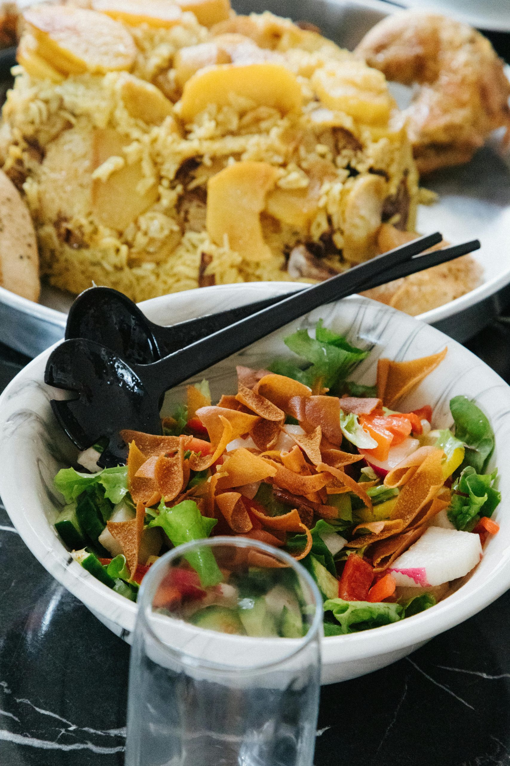 Close-up d'une salade fraîche avec un plat de riz sur une table en marbre, mettant en valeur des couleurs et des textures vibrantes.