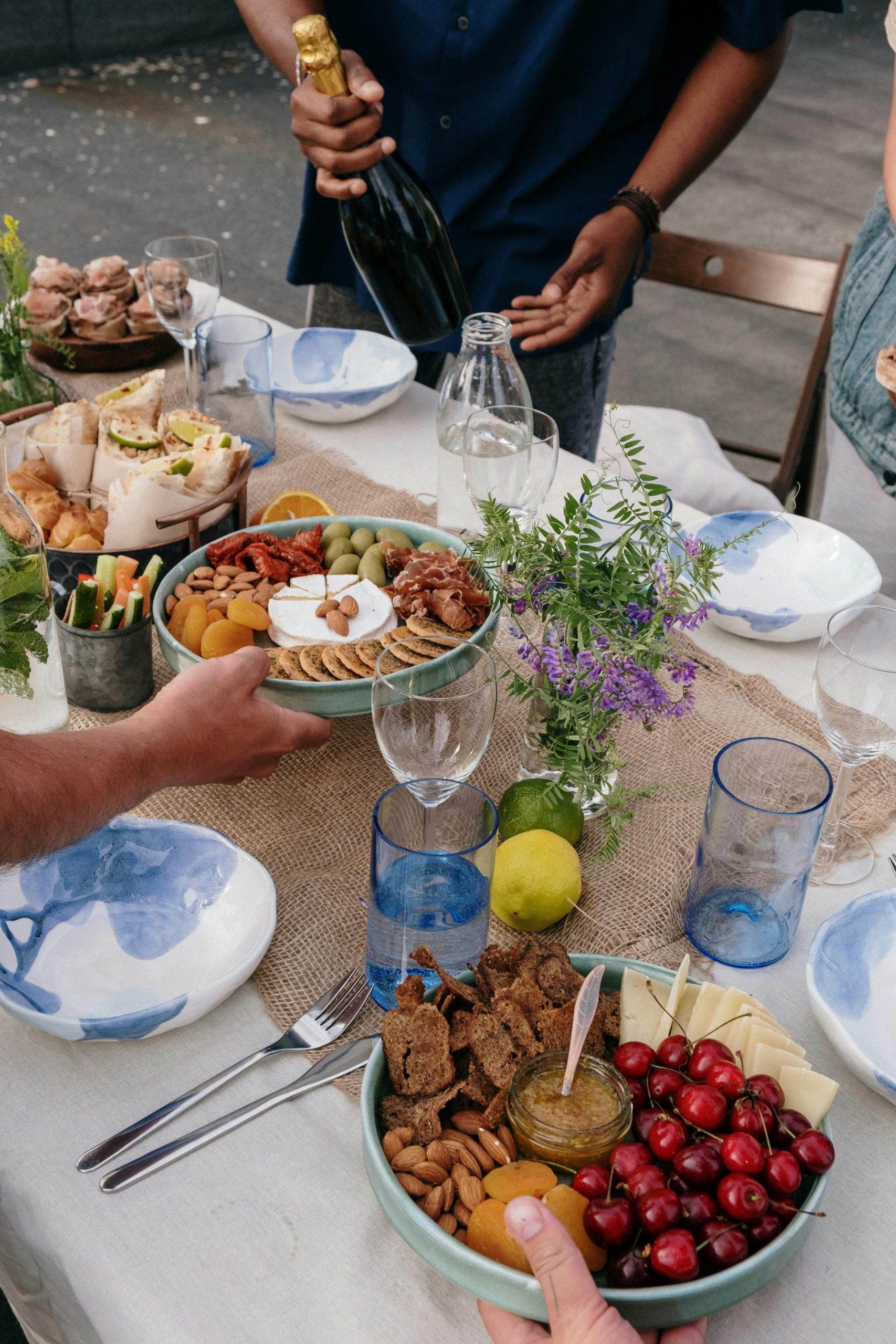 Enjoy a delightful outdoor brunch with friends featuring a variety of snacks and a celebratory atmosphere. Profitez d'un délicieux brunch en plein air entre amis, avec une variété de collations et une ambiance festive.