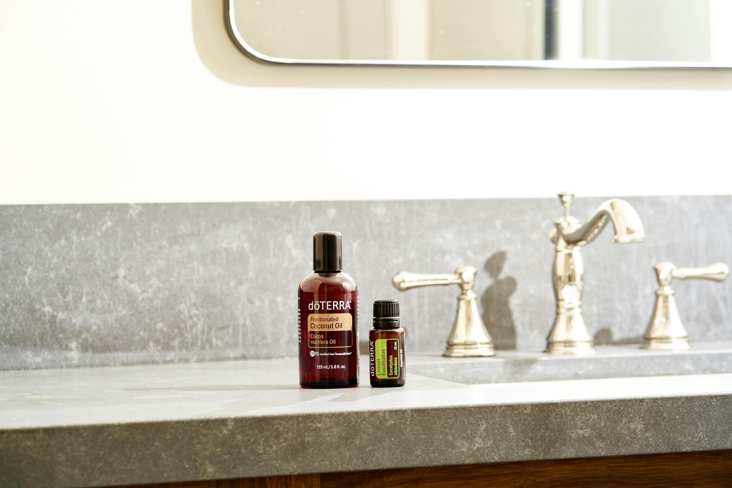 Beautiful display of essential oils on a modern bathroom countertop with a stylish faucet. Affichage magnifique d'huiles essentielles sur un plan de travail moderne de salle de bain avec un robinet élégant.