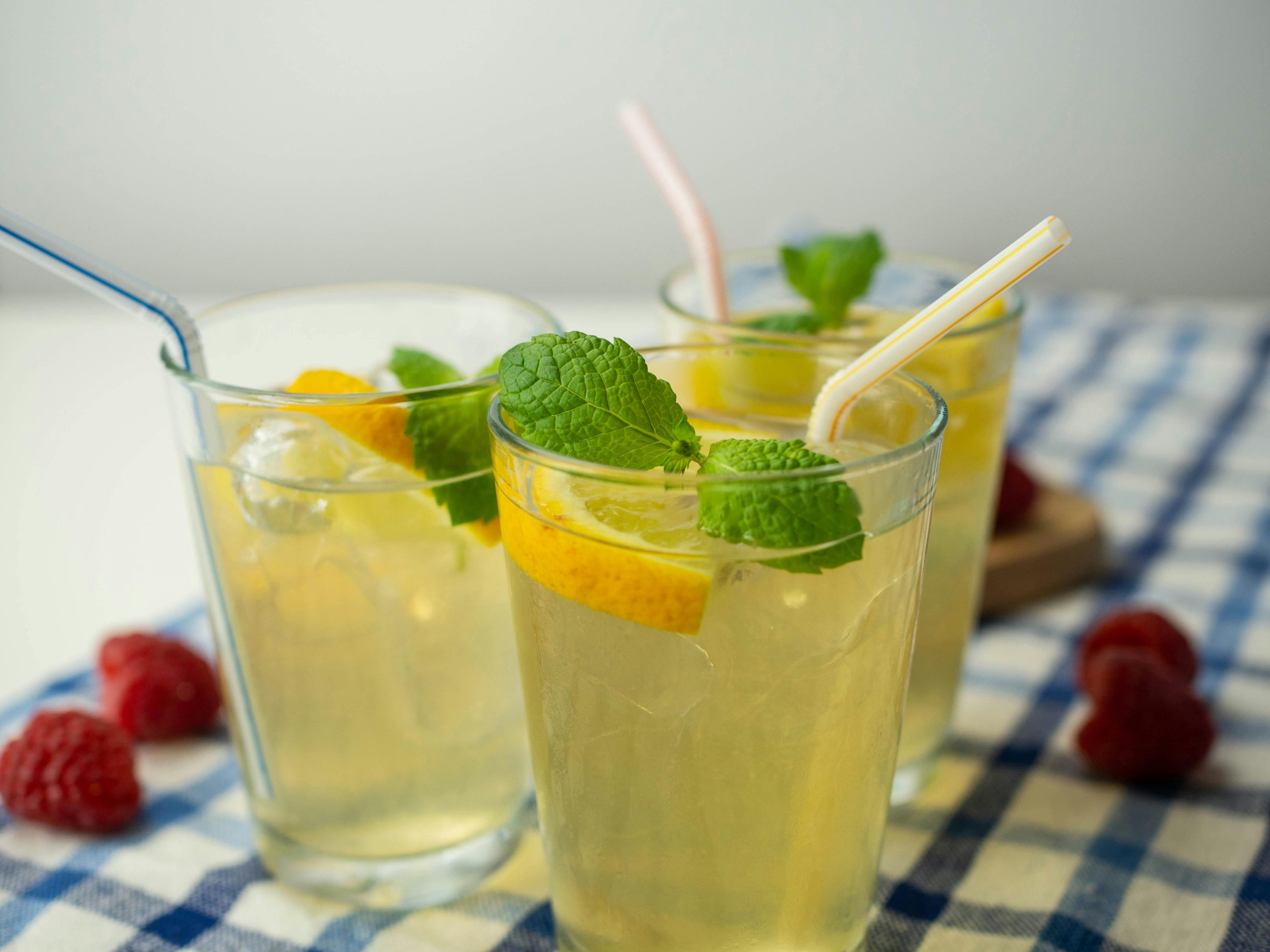 Fresh lemonade avec feuilles de menthe et framboises, parfaite pour se rafraîchir en été.