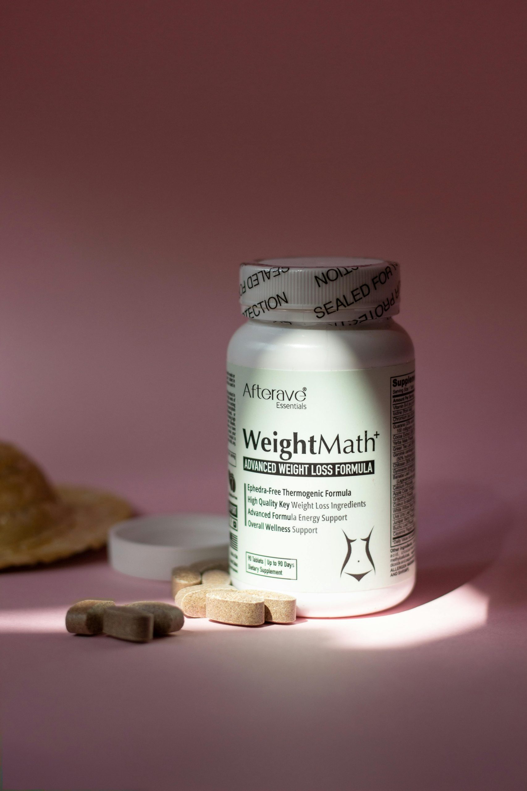 WeightMath flacon de complément vitaminé pour la gestion du poids avec des pilules sur une surface rose