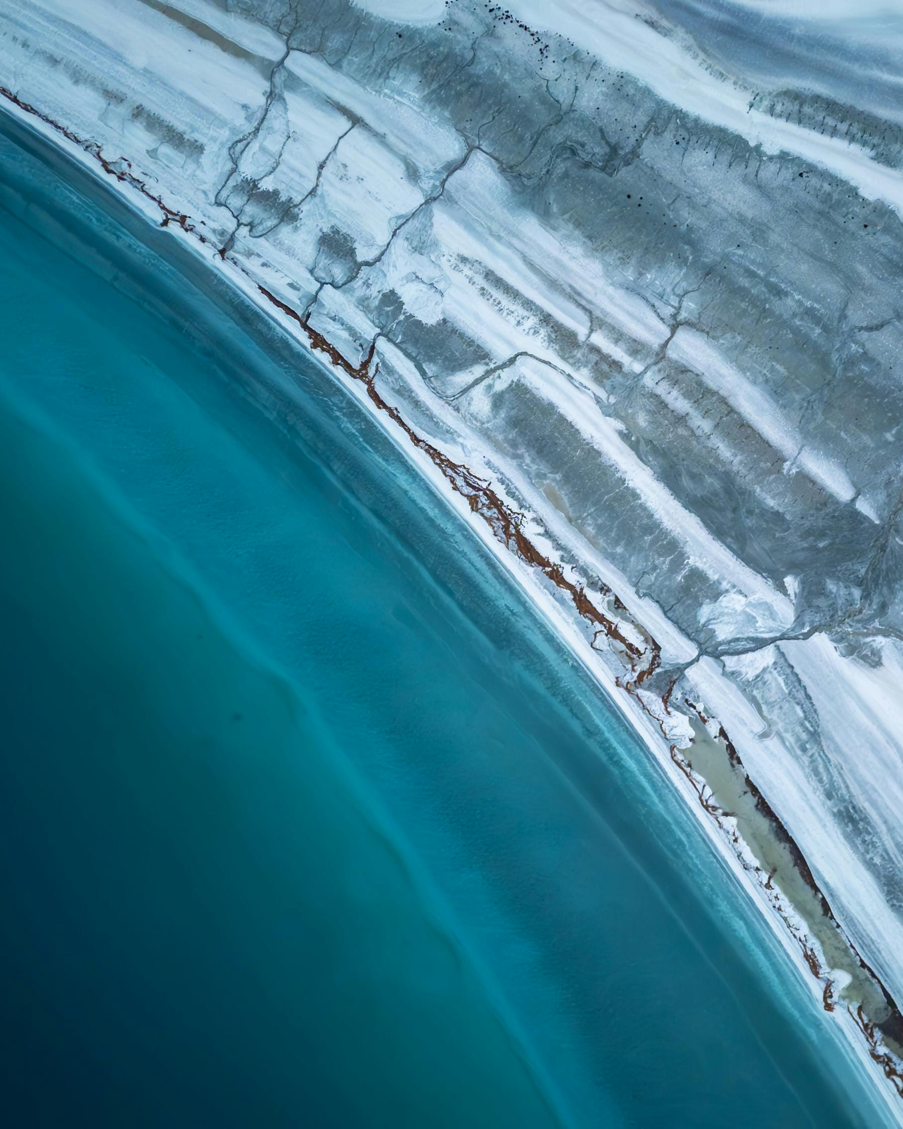 Stunning aerial shot of the turquoise shoreline and salt formations at Salda Lake, Türkiye. Vue aérienne spectaculaire du littoral turquoise et des formations de sel du lac Salda, Türkiye.