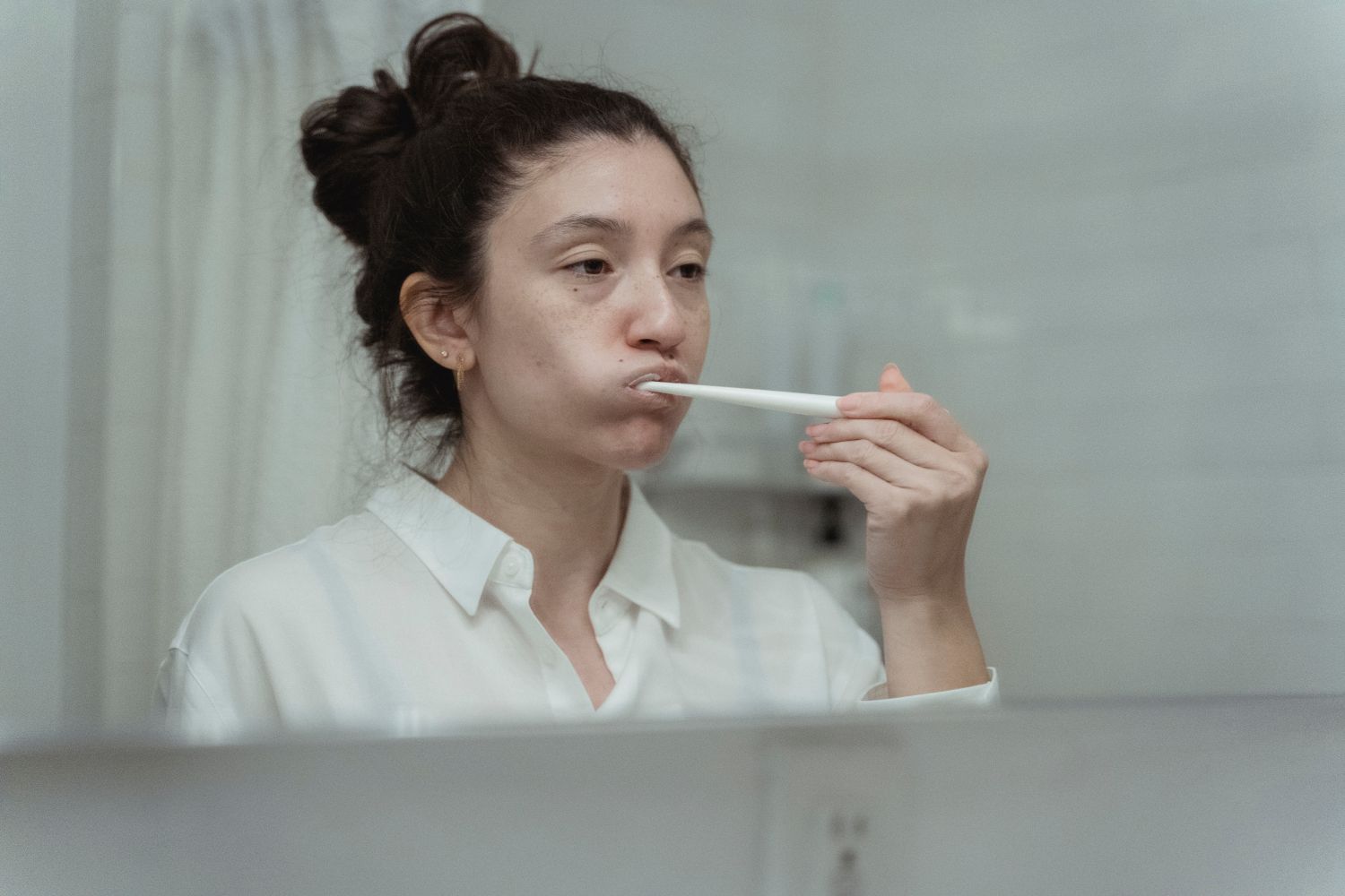 Femme se brossant les dents devant un miroir