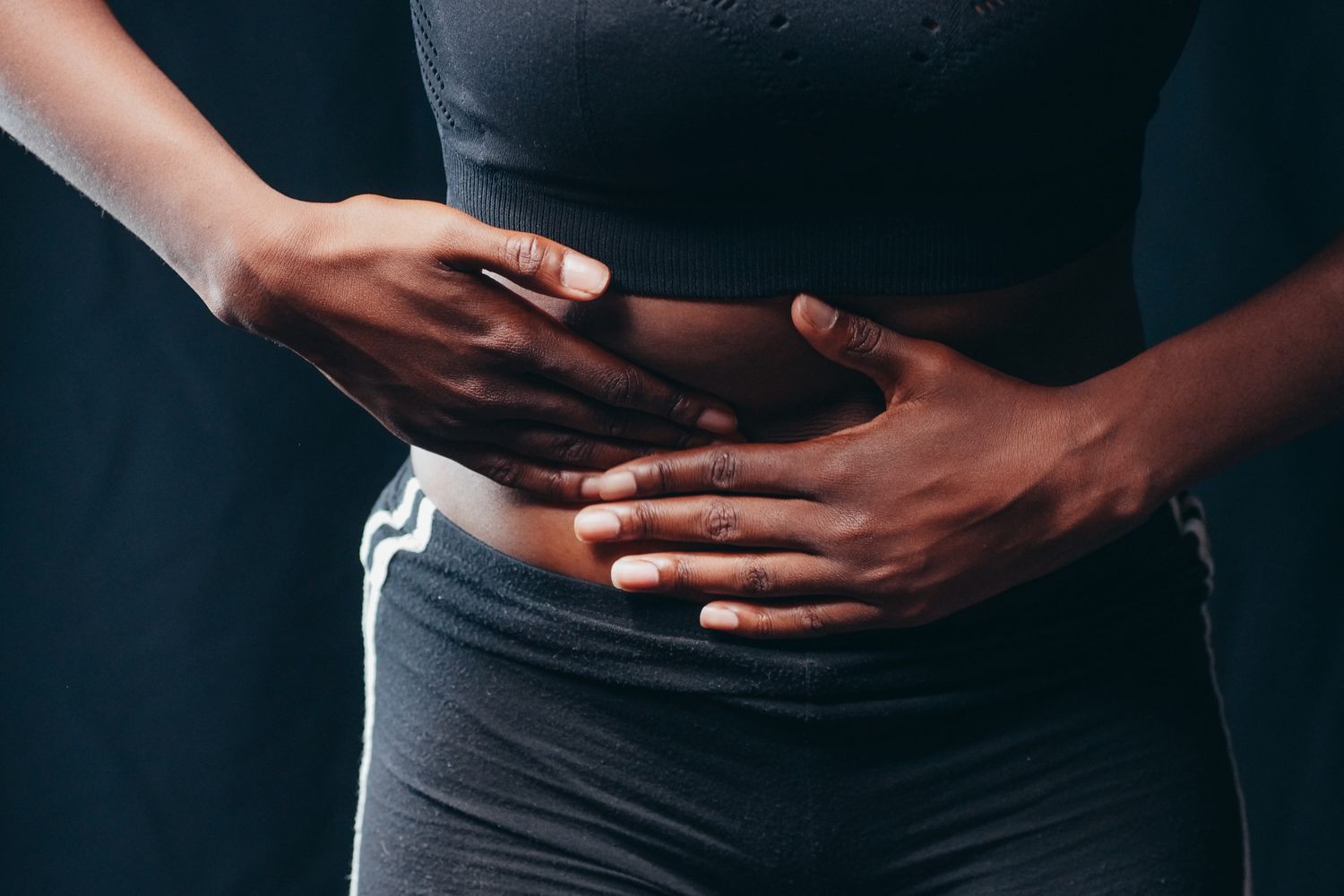 Personne se tenant le ventre à cause d'une douleur digestive