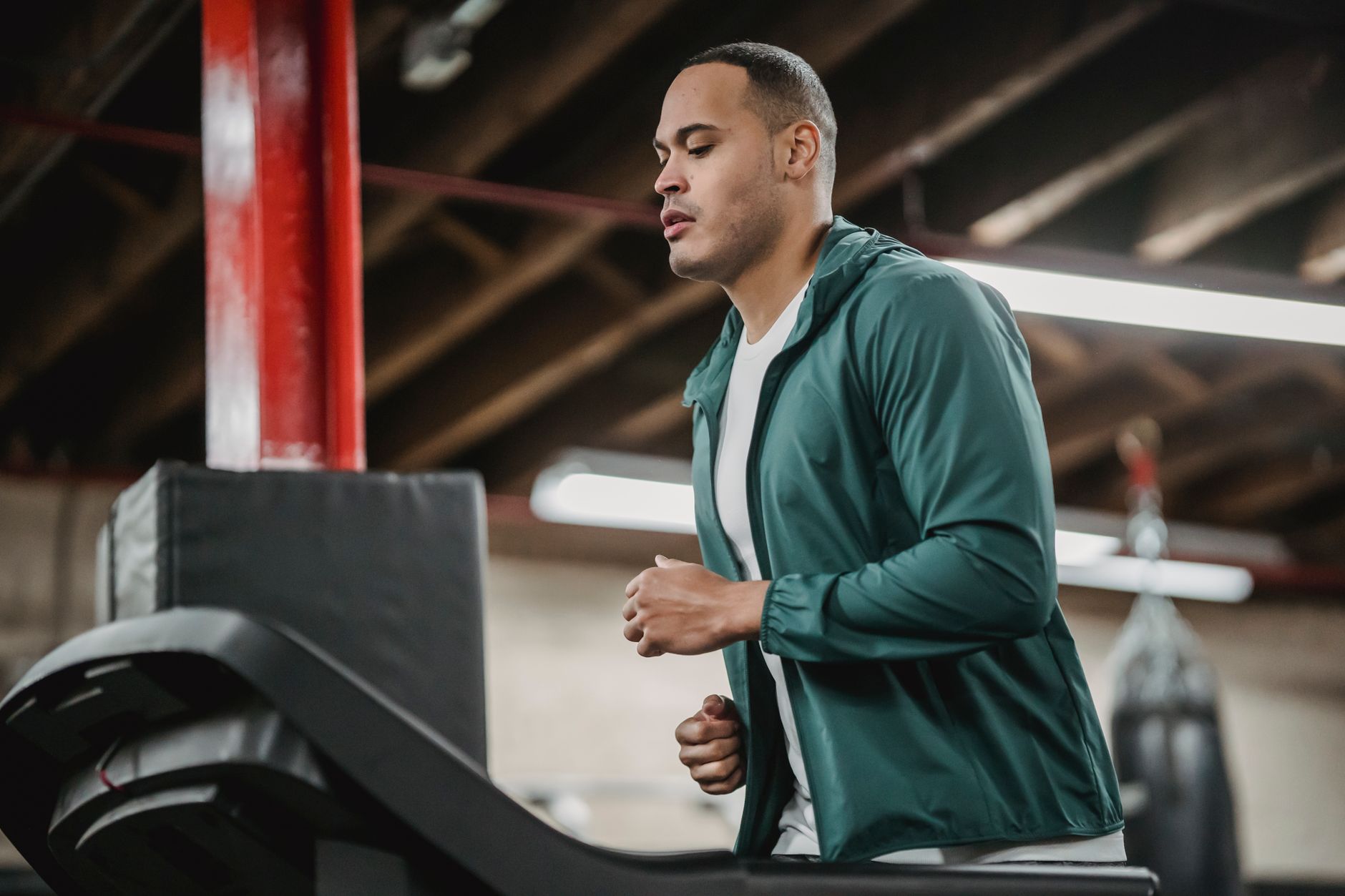 Homme en jogging sur un tapis en salle de sport