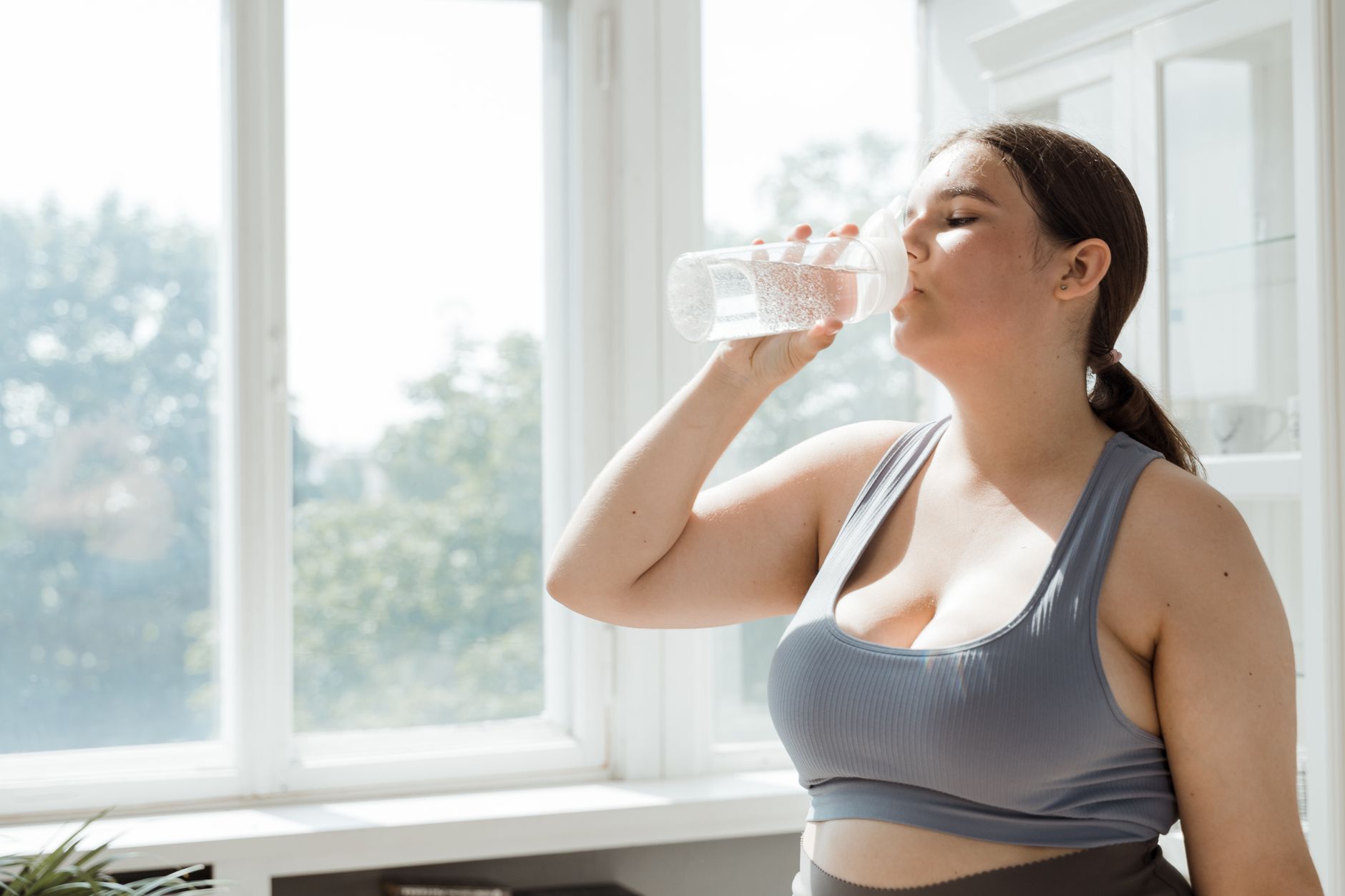 Femme qui boit de l'eau après une séance de sport