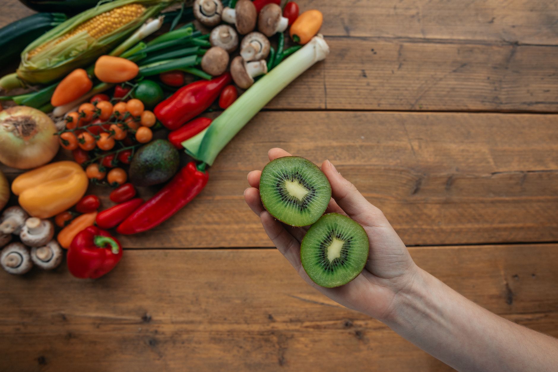 Kiwi tranché et légumes frais sur une table en bois