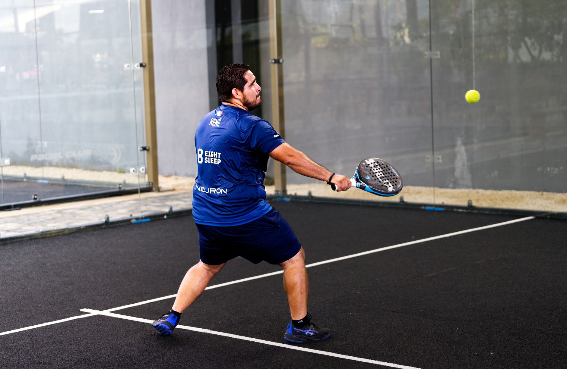 Joueur de padel en plein echange sur un court exterieur