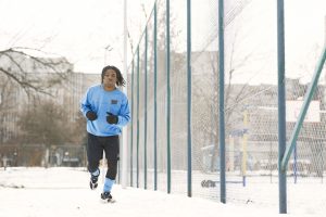 Coureur qui progresse sur un chemin enneigé
