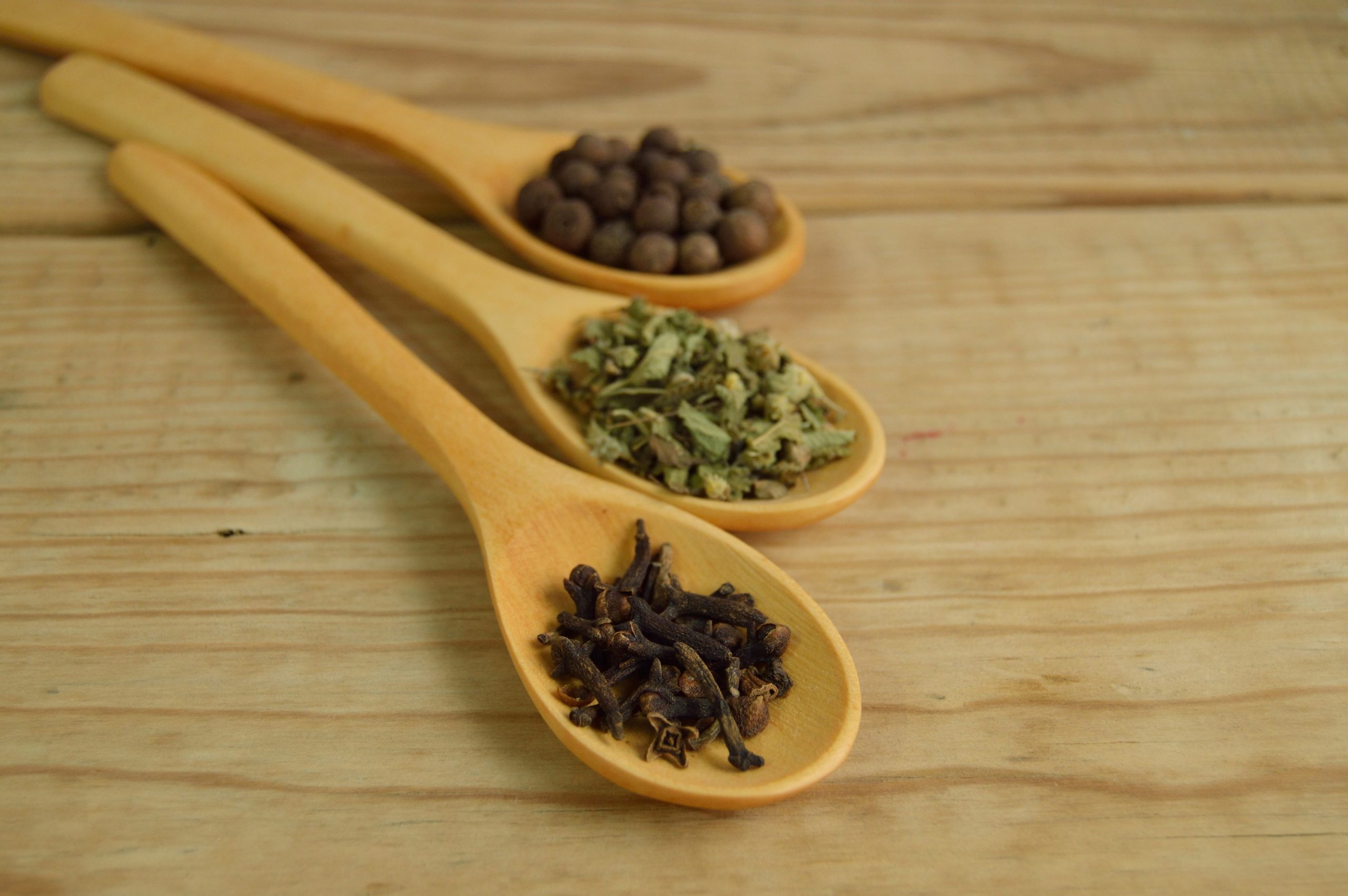 Cuillères en bois remplies d’épices aromatiques
