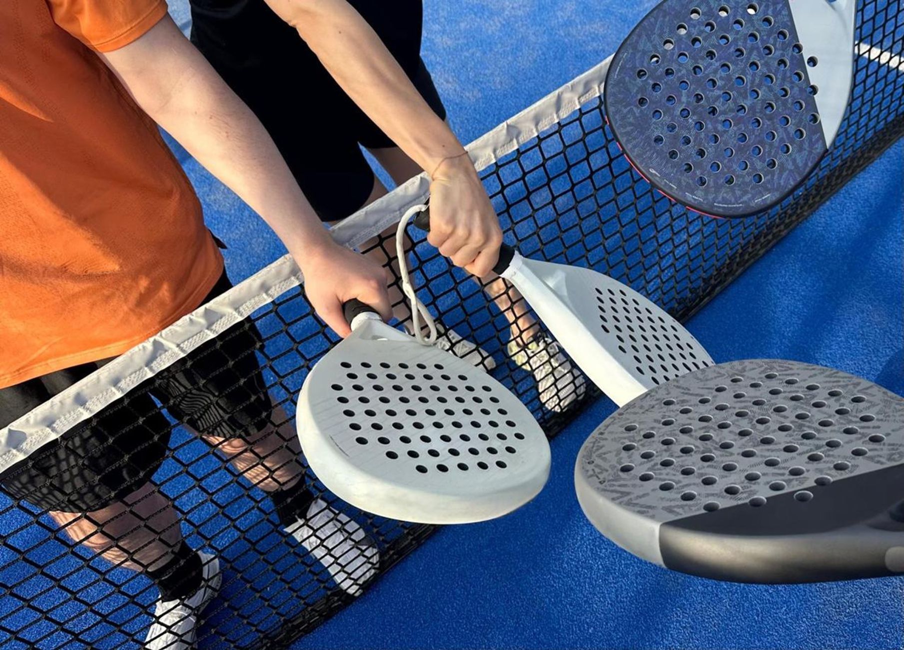 Deux joueurs de padel se saluent au filet après un point