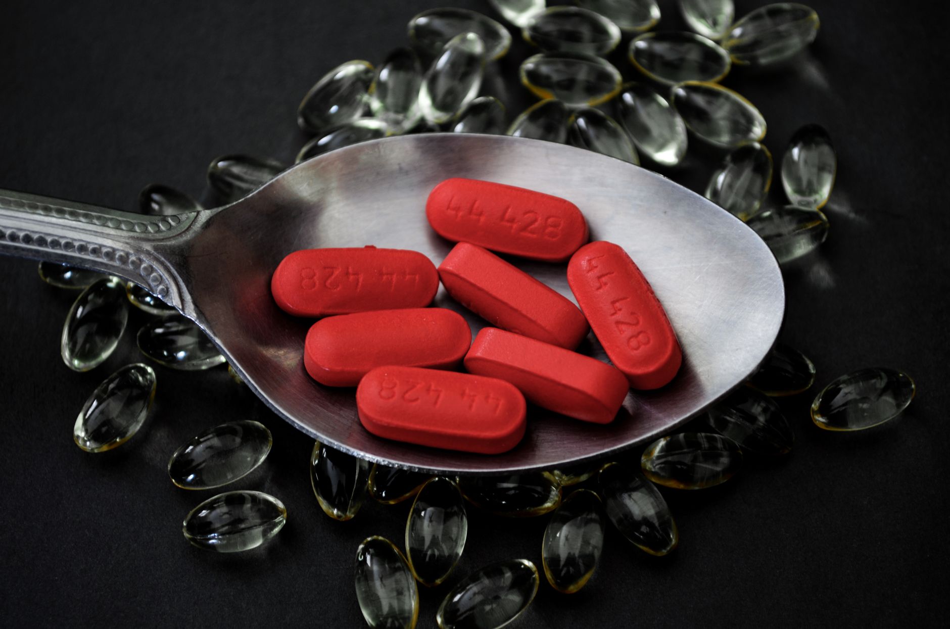Comprimés rouges de vitamine sur une cuillère