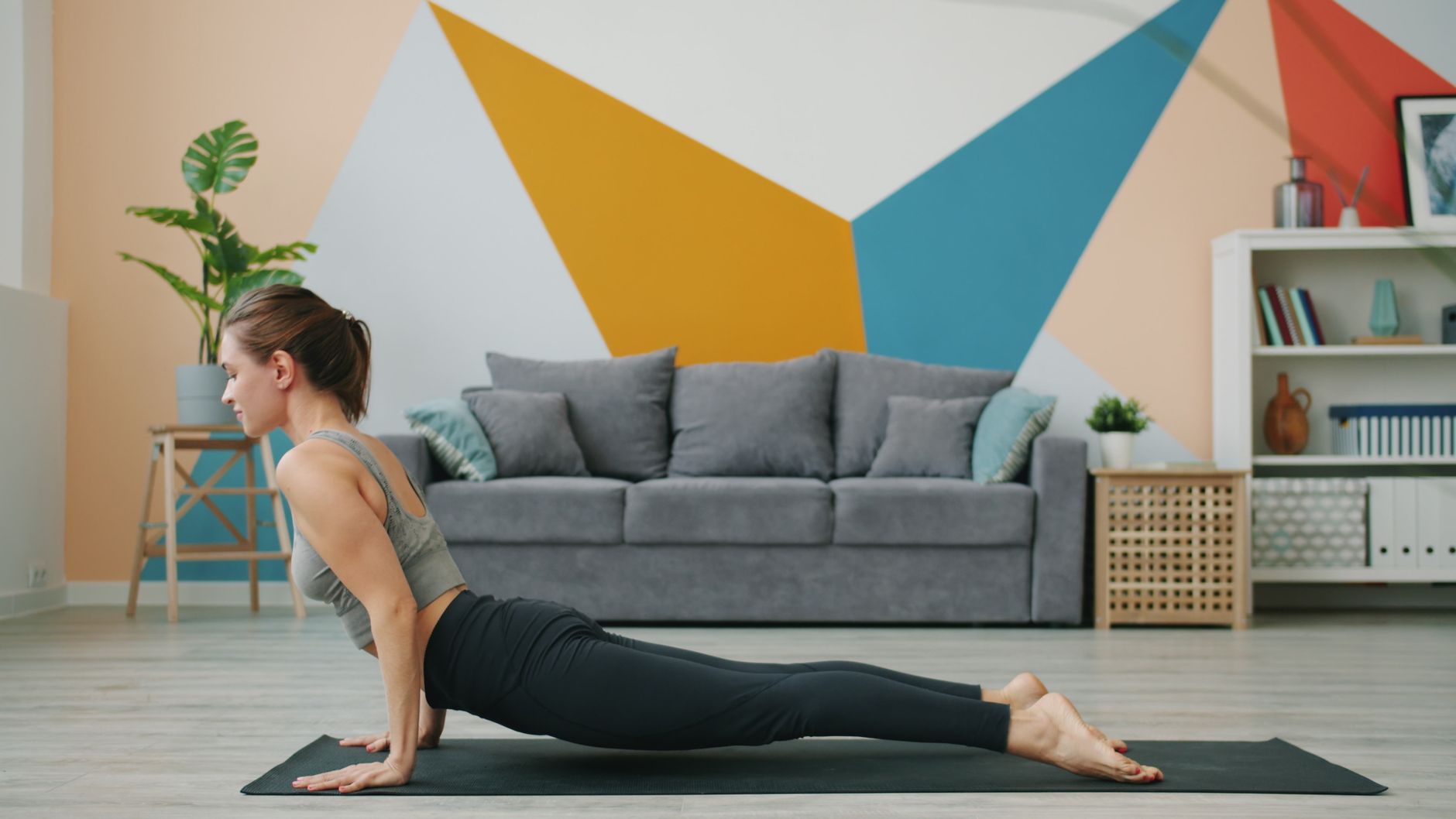 Séance de yoga à la maison devant un mur décoré