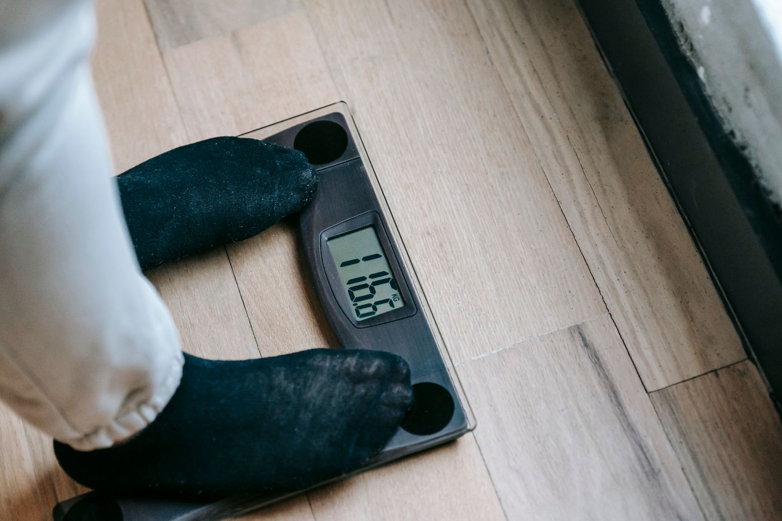 Personne en chaussettes qui se pèse sur une balance électronique