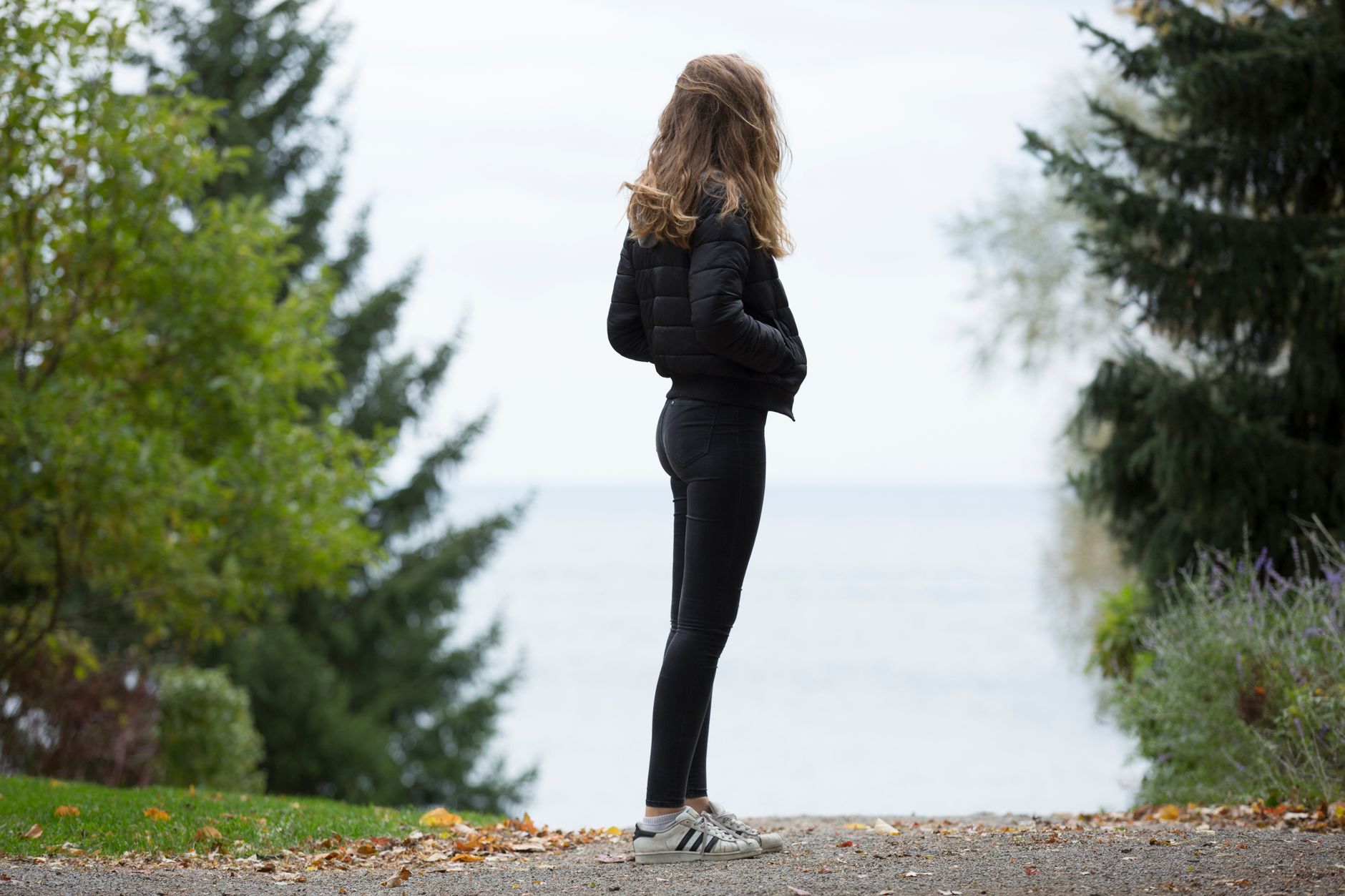 Femme debout sur un sentier entre les arbres