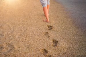 Empreintes de pas nus sur une plage de sable