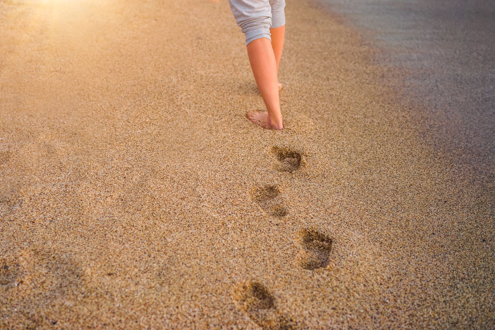 Empreintes de pas nus sur une plage de sable